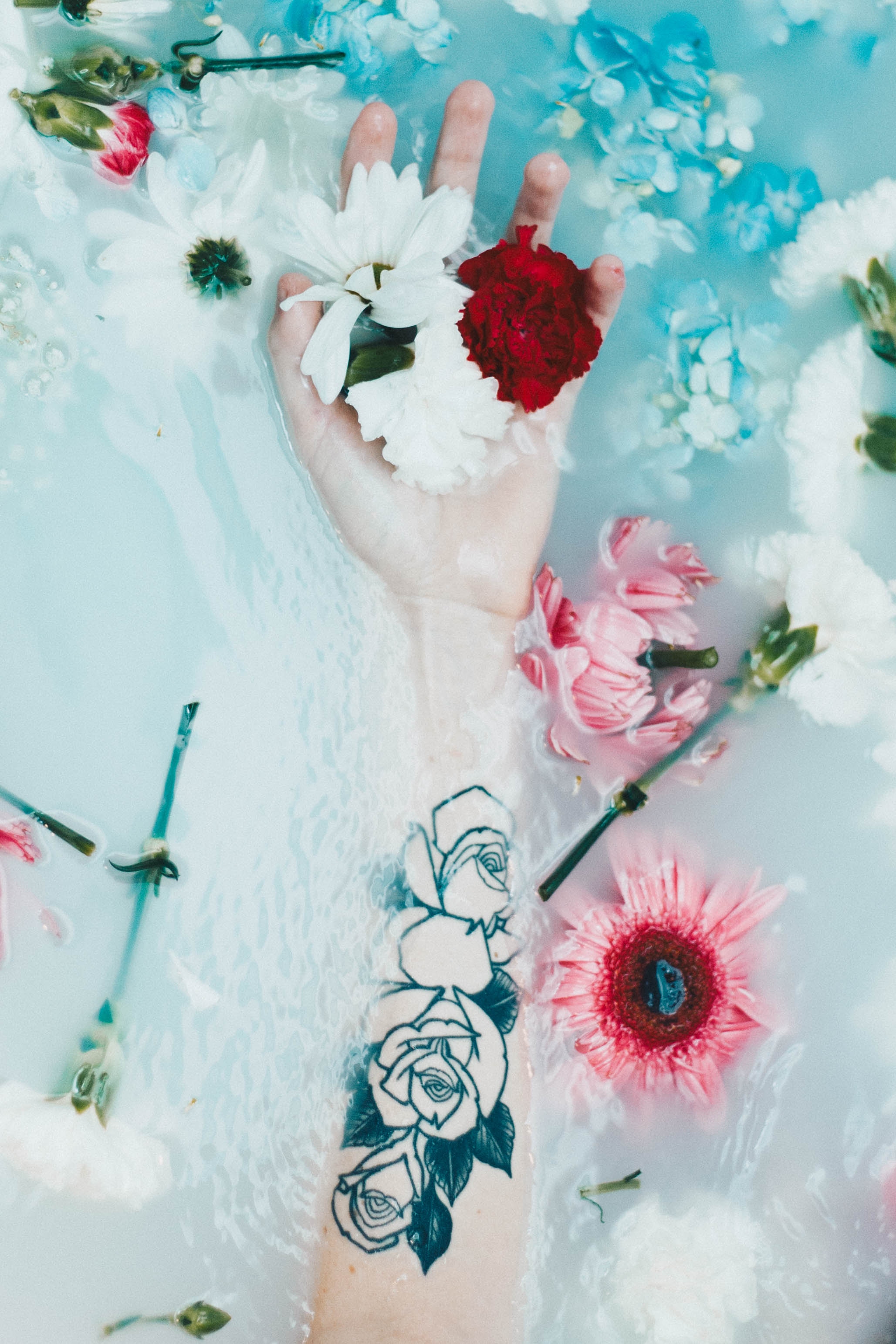 Download wallpaper 2057x3086 hand, tattoo, flowers, water hd background