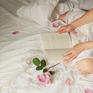 Preview wallpaper hands, book, flowers, petals, bed