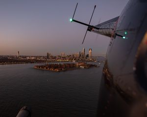 Preview wallpaper helicopter, city, island, buildings, aerial view