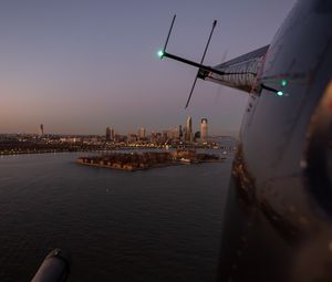 Preview wallpaper helicopter, city, island, buildings, aerial view