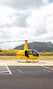 Preview wallpaper helicopter, yellow, asphalt, hill