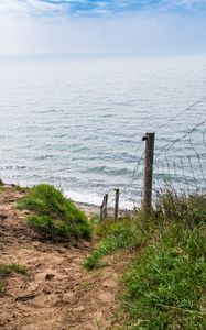 Preview wallpaper hill, grass, sea, fence, grid, view