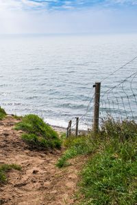 Preview wallpaper hill, grass, sea, fence, grid, view