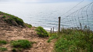 Preview wallpaper hill, grass, sea, fence, grid, view