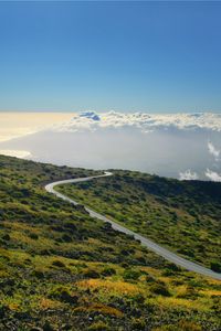 Preview wallpaper hill, mountain, slope, road, grass, clouds