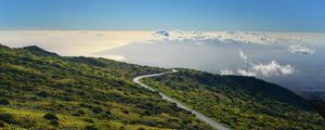 Preview wallpaper hill, mountain, slope, road, grass, clouds