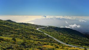 Preview wallpaper hill, mountain, slope, road, grass, clouds