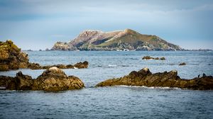 Preview wallpaper hill, rocks, stones, sea, nature