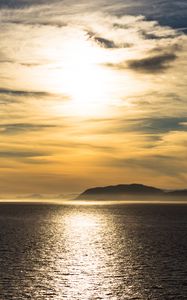 Preview wallpaper hill, sunset, clouds, sea, glare