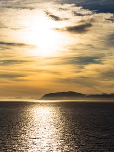 Preview wallpaper hill, sunset, clouds, sea, glare