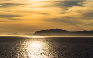 Preview wallpaper hill, sunset, clouds, sea, glare