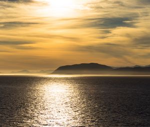 Preview wallpaper hill, sunset, clouds, sea, glare