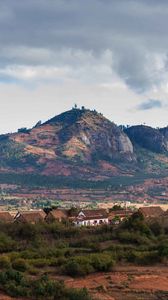 Preview wallpaper hill, trees, buildings, bushes, sky