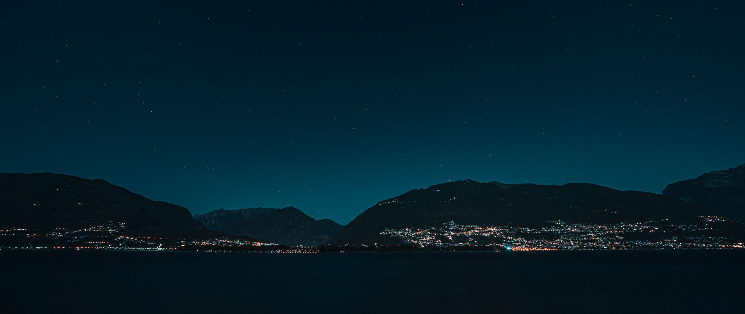 Download wallpaper 2560x1080 hills, night, starry sky, stars, sea dual