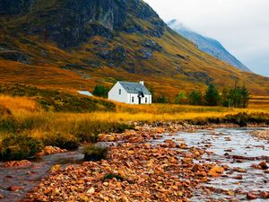 Preview wallpaper house, lake, stones, grass, mountains