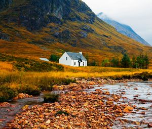 Preview wallpaper house, lake, stones, grass, mountains