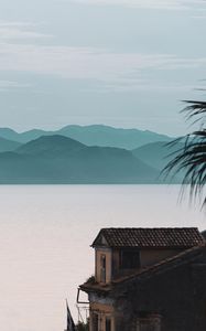 Preview wallpaper house, sea, mountains, fog, building, shore