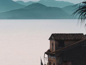 Preview wallpaper house, sea, mountains, fog, building, shore