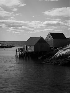 Preview wallpaper houses, river, pier, piles, bw