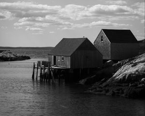 Preview wallpaper houses, river, pier, piles, bw