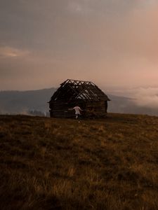 Preview wallpaper hut, ruins, man, mountains, lonely, abandoned