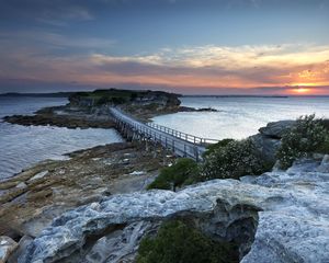 Preview wallpaper island, bridge, sea, stones, dusk