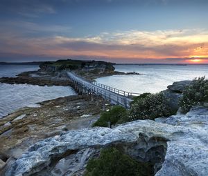 Preview wallpaper island, bridge, sea, stones, dusk