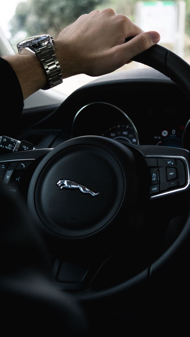 800x1420 Wallpaper jaguar, steering wheel, hand, watch