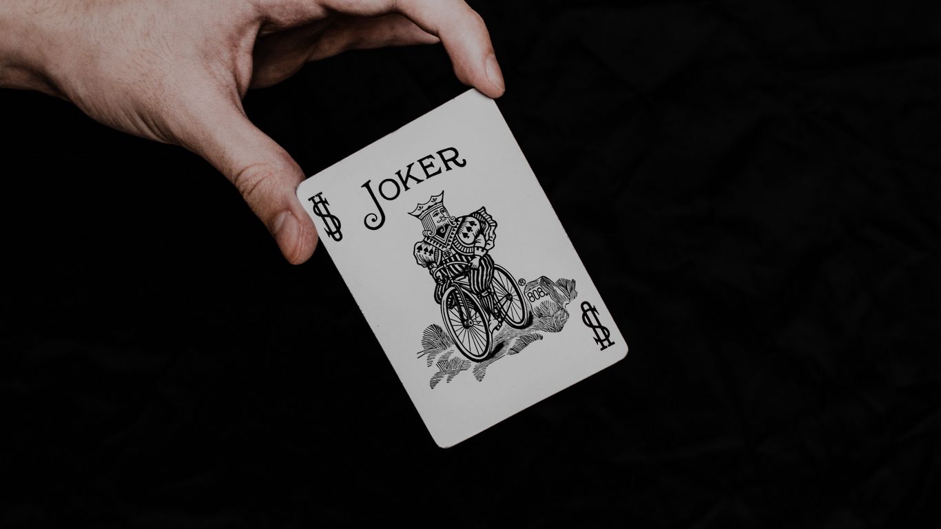 Download wallpaper 1366x768 joker, playing card, card, word, hand