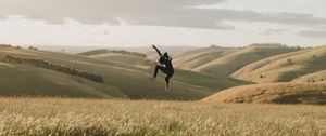 Preview wallpaper jump, levitation, silhouette, field, hills