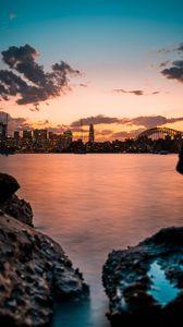 Preview wallpaper lake, city, buildings, coast, sunset