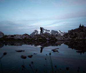 Preview wallpaper lake, mountains, silhouette, stones, shore