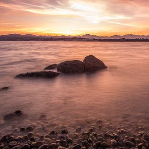 Preview wallpaper lake, pebbles, stones, hills, sunrise