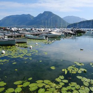 Preview wallpaper lake, pier, boats, mountains, water lilies, nature