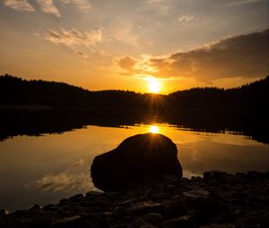 Preview wallpaper lake, stone, sunset, reflection, sun, sky, forest, coast