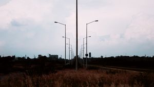 Preview wallpaper lampposts, twilight, sunset, grass