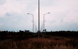 Preview wallpaper lampposts, twilight, sunset, grass