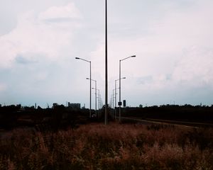 Preview wallpaper lampposts, twilight, sunset, grass