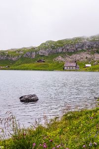 Preview wallpaper landscape, lake, houses, stone, shore, grass