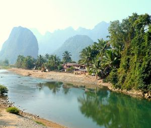 Preview wallpaper laos, tropics, palm trees, river, huts