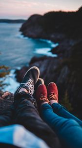 Preview wallpaper legs, shoes, sneakers, cliff, sea