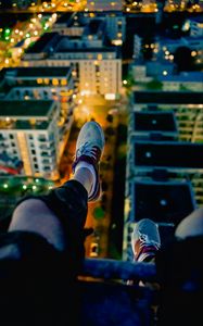 Preview wallpaper legs, sneakers, city, lights, aerial view