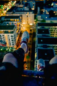 Preview wallpaper legs, sneakers, city, lights, aerial view