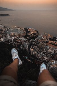 Preview wallpaper legs, sneakers, city, aerial view, coast