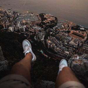 Preview wallpaper legs, sneakers, city, aerial view, coast