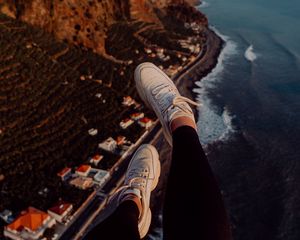 Preview wallpaper legs, sneakers, city, aerial view, coast, mountains