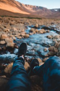 Preview wallpaper legs, sneakers, coast, stones, mountains