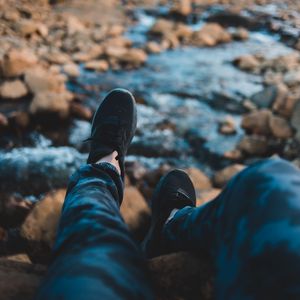 Preview wallpaper legs, sneakers, coast, stones, mountains