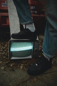 Preview wallpaper legs, sneakers, screen, tv, jeans