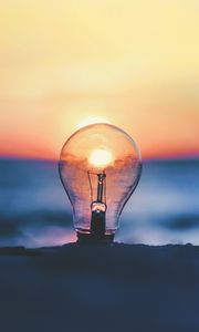 Preview wallpaper light bulb, sunset, sun, focus